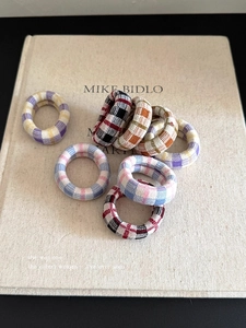 Detailed view of high-elasticity thick plaid knit hair ties on a vintage linen book cover