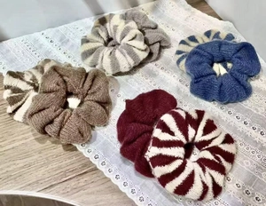 Vue détaillée de cinq chouchous en maille douce à rayures rouges et blanches assorties