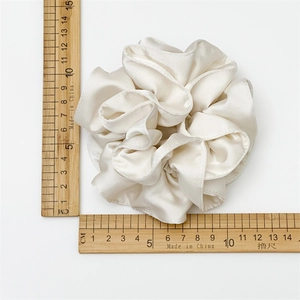 Glossy cream satin scrunchie with layered pleats for elegant low ponytail hairstyles