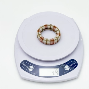 Close-up of a 4.4g durable seamless checkered hair tie on a white digital scale