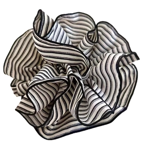 Retro black and white striped fabric scrunchie with oversized flower-like pleated design