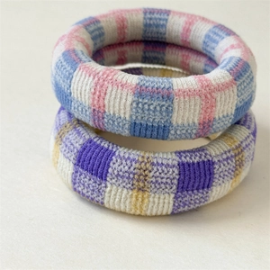 Close-up of thick knitted checkered hair scrunchies showing detailed fabric texture