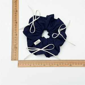 Navy blue oversized scrunchie with white wavy bow knots and handmade tag, 11.5cm wide