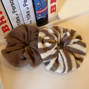 Lot de deux chouchous en tricot marron uni et à rayures crème posés sur un plateau