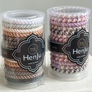 Macro detail of high-elasticity ponytail holders in clear cylindrical storage jars