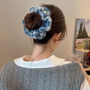 Detail of blue and white checkered knitted scrunchie styled on a bun hairstyle