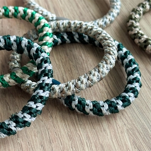 Close-up of woven high-elastic ponytail hair ties in various colors on wooden surface