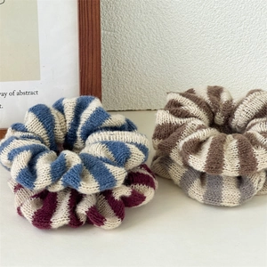 Gros plan détaillé de chouchous en tricot à rayures bleues, bordeaux et marron