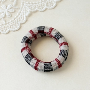 Detailed close-up of seamless red, white, and blue plaid pattern elastic hair tie