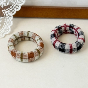 Thick knit hair scrunchies with retro plaid patterns in green and red checkered fabric