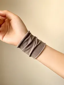 Texture dettagliata dell'elastico marrone senza cuciture sul polso con pieghe morbide