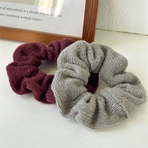 Gros plan de chouchous tricotés rouges et gris montrant la texture douce et les détails