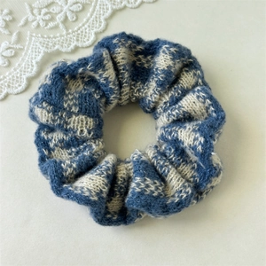 Detailed macro view of the vintage navy and beige knit plaid texture scrunchie