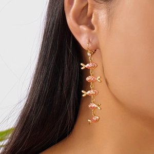 Vue détaillée de longues boucles d'oreilles à pampilles avec poissons en émail rose