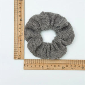 Vue détaillée d'un chouchou en tricot gris montrant un diamètre de 10 cm sur une règle
