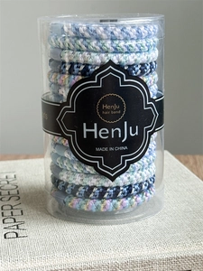 Colorful woven elastic hair bands with metallic thread detail in a clear cylinder jar