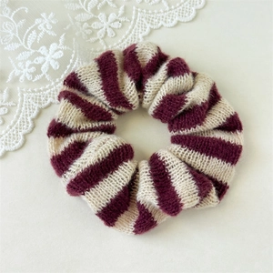 Détail d'un chouchou en tricot à rayures rouges et blanches avec une texture douce et chic