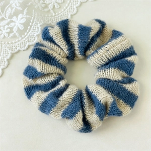 Gros plan d'un chouchou en tricot rayé bleu et blanc avec texture en laine douce