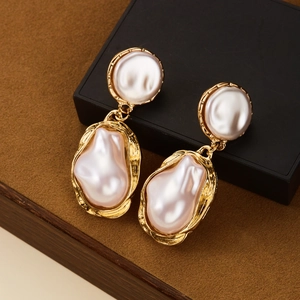 Gros plan détaillé de boucles d'oreilles vintage en perles baroques sur boîte noire