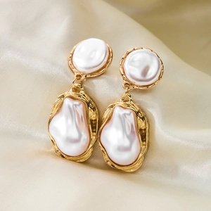 Vue détaillée de boucles d'oreilles vintage avec perles baroques et monture dorée texturée