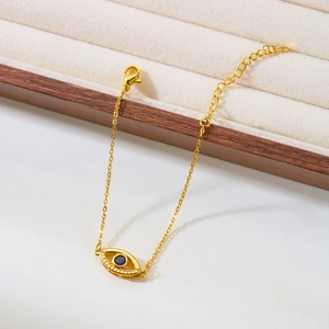 Detail of gold evil eye bracelet with blue center stone and adjustable lobster clasp