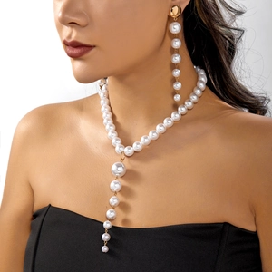 Elegant Y-shaped pearl necklace and drop earring set with gold accents on female model