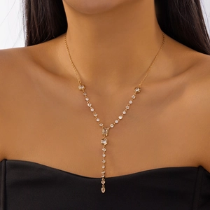 Close-up of golden Y-shaped long necklace with geometric zircon pendants on model