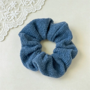 Vue détaillée du chouchou en maille bleu Morandi montrant la texture douce du fil tricoté