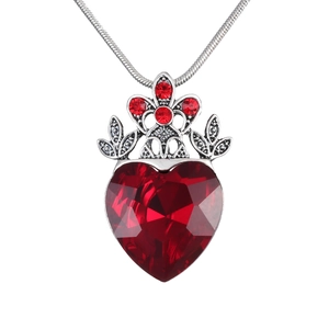 Macro detail of gothic silver crown and red heart gemstone pendant on a snake chain