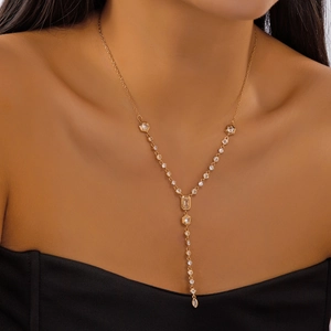 Detail of elegant gold Y-shaped layered necklace with sparkling zircon drop pendant