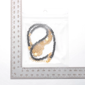 Dettaglio della collana di perline con stelle e scala graduata per guida alle taglie