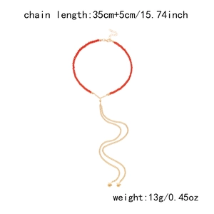 Dettaglio della collana di perline rosse con catene dorate, stelle e dimensioni prodotto