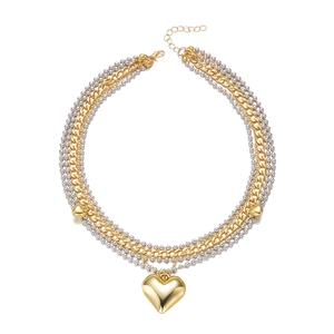 Détail d'un collier multicouche avec pendentif coeur doré et textures de chaînes mixtes