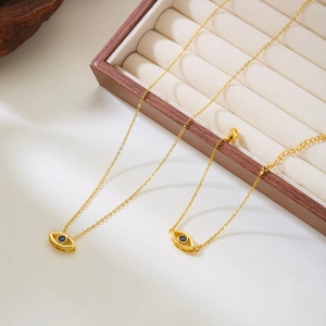 Elegant gold Evil Eye jewelry set with blue crystal necklace and bracelet on beige display