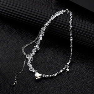 Detailed macro view of a heart pendant necklace with white crystal beads and star charm