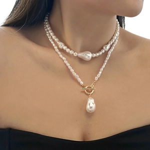 Gros plan d'un collier double rang en perles baroques avec fermoir OT doré sur modèle