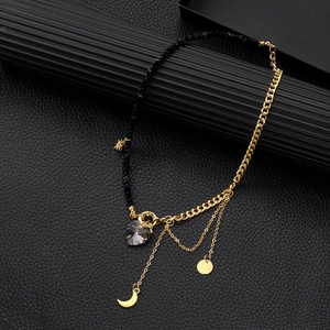 Detailed close-up of mixed gold chain and black beads with heart and moon pendants