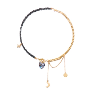 Detail of multi-element gold chain and black bead necklace with crystal heart pendant