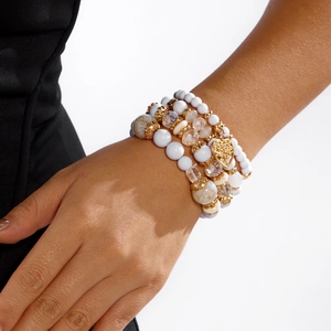 Detailansicht der mehrlagigen Boho-Perlenarmbänder mit goldenem Herzanhänger