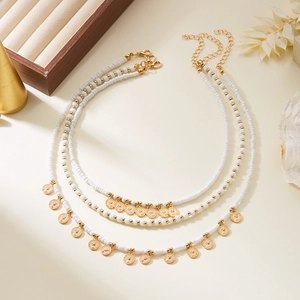 Collier bohème à trois rangs avec perles blanches et pendentifs pièces dorées gravées