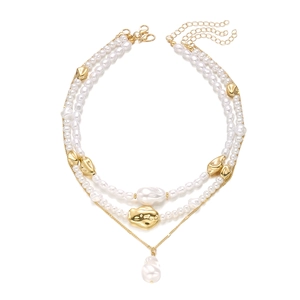 Détail macro du collier trois rangs en perles baroques avec chaîne dorée et fermoir OT