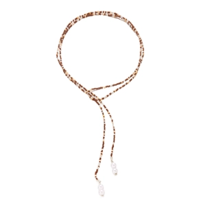Dettaglio della collana di perline ambrate con pendenti di perle bianche e nappe