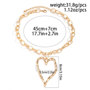 Detailed view of large golden hammered heart pendant with chunky chain dimensions