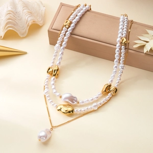 Détail d'un collier de perles baroques irrégulières avec fermoir OT et chaîne dorée