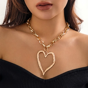 Chunky gold chain necklace with oversized hammered heart pendant on black knitwear