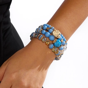 Detail eines mehrlagigen böhmischen Armbands in Himmelblau mit goldenem Herzanhänger