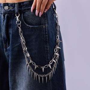 Dettaglio della catena per pantaloni multistrato argento con borchie punk su jeans