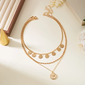 Vue détaillée du collier multi-rangs doré avec pendentifs portraits vintage et coquillages