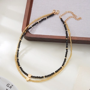 Double-layered beaded necklace with black faceted beads and polished gold heart pendants