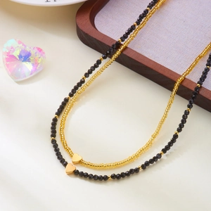 Double-layered beaded necklace set with black facet beads and gold heart pendants